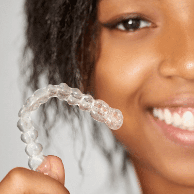 black woman holding braces Invisalign clear great smile
